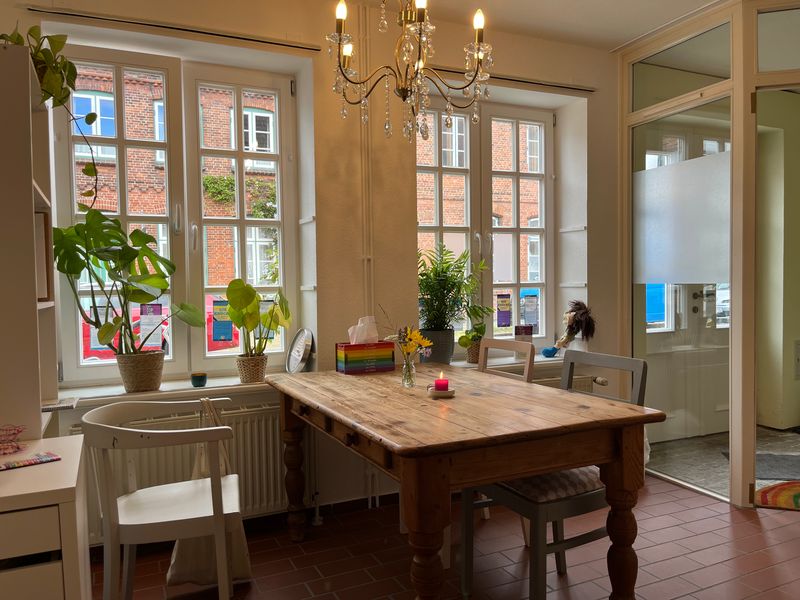 Heller Beratungsraum der Familienberatung Die Krücke in Friedrichstadt mit Holztisch, Pflanzen und Sprossenfenstern